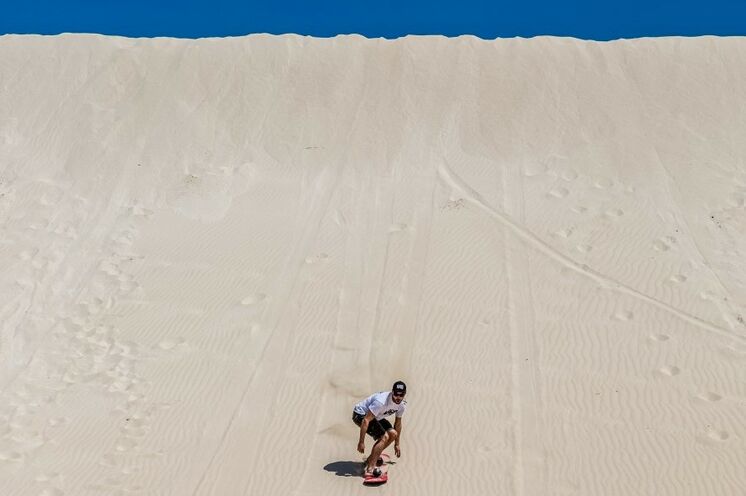 Wagemutige können sich in den hohen, schneeweißen Sanddünen bei Lancelin beim Sandboarding versuchen
